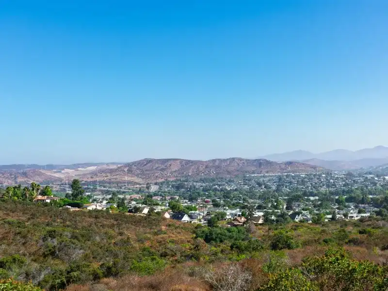 Hilly landscape with scattered houses and a clear blue sky above water damage restoration in Santee