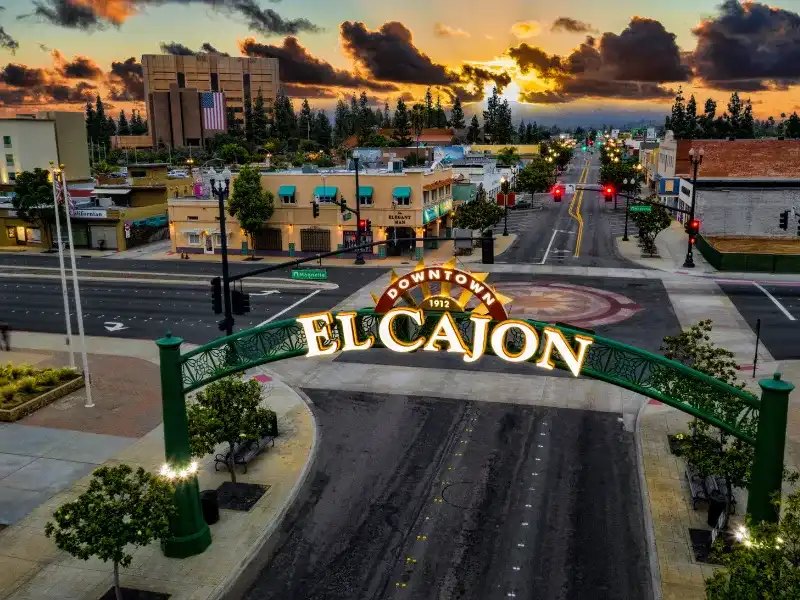 Downtown El Cajon archway over a street at sunset with buildings and trees in the background water damage restoration in El Cajon