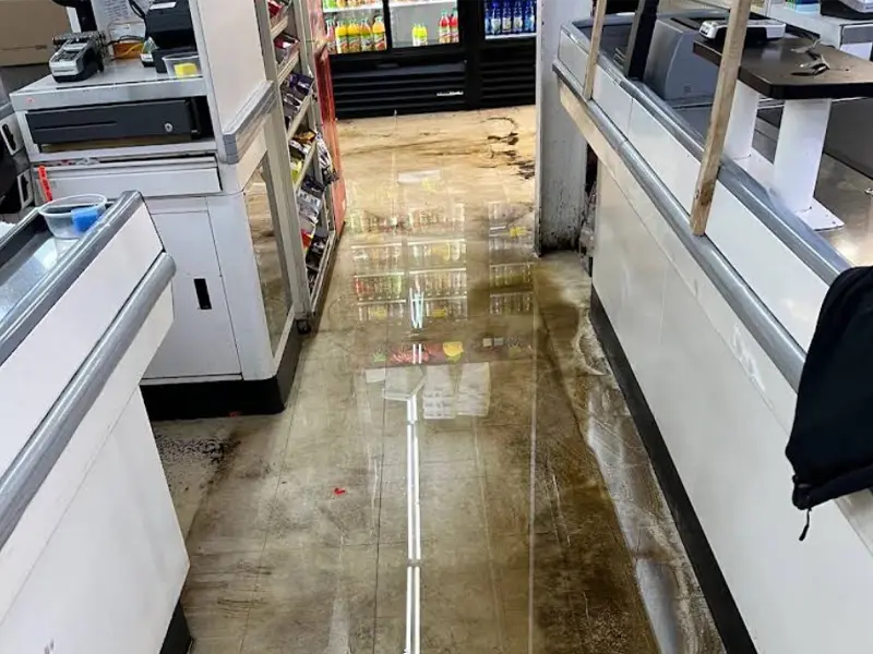 Water flooding the floor between checkout counters in a store. commercial water damage restoration
